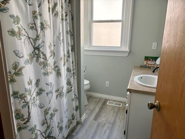 Bathroom with visible vents, baseboards, toilet, wood finished floors, and vanity | Image 23