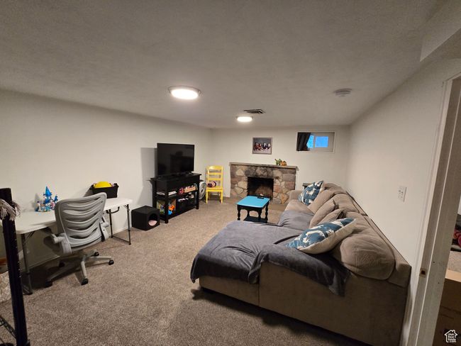 Living room with visible vents, carpet flooring, and a fireplace | Image 34