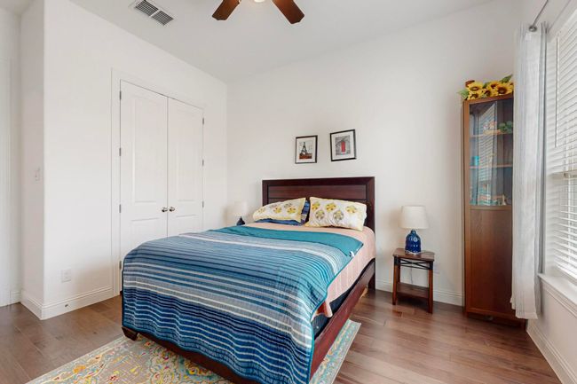 Bedroom with baseboards, wood finished floors, a closet, and visible vents | Image 20