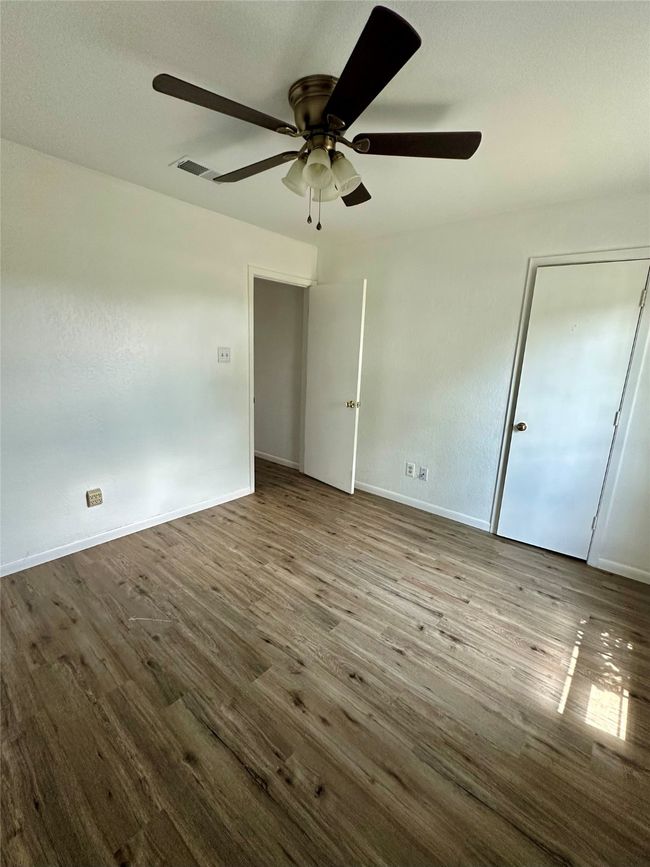 Unfurnished bedroom with wood finished floors and a ceiling fan | Image 15