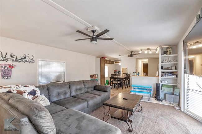 Living room with plenty of natural light, a ceiling fan, and vaulted ceiling | Image 19