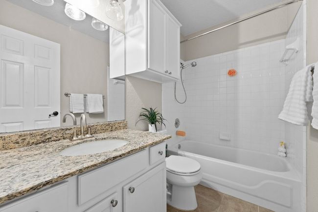Guest/second Full bath with granite vanity, shower / washtub combination, and tile flooring | Image 19