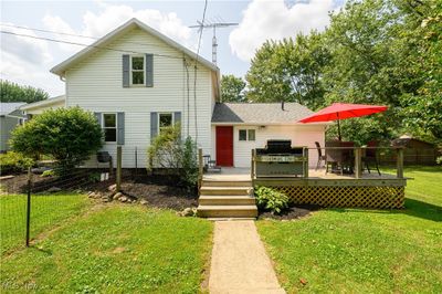 View of front of home featuring a wooden deck and a front yard | Image 1