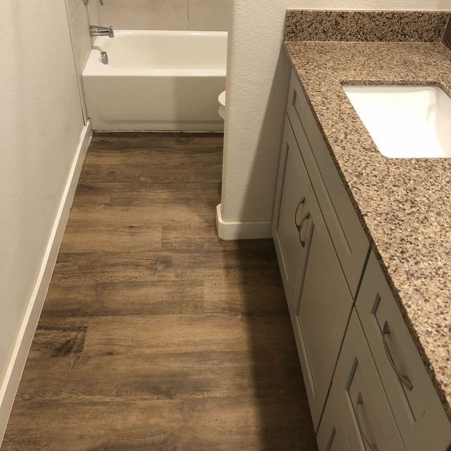 Full bath with wood finished floors, baseboards, vanity, a tub, and toilet | Image 16