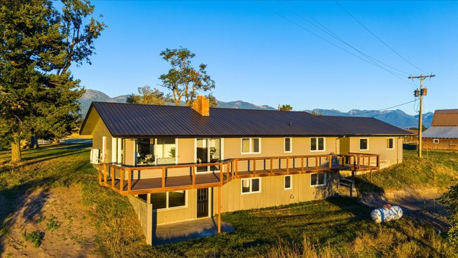 Rear view of property featuring a deck with mountain view and a yard | Image 49