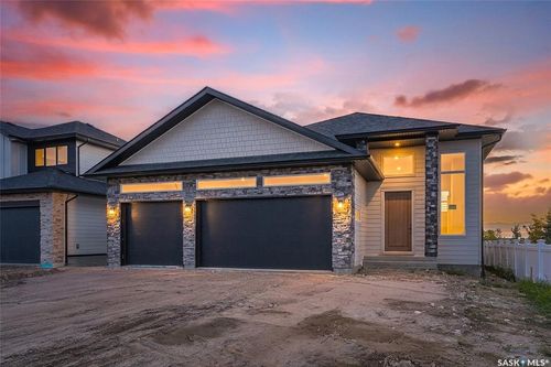 Modern exterior with stone accents, horizontal siding, and a two-car garage | Card Image