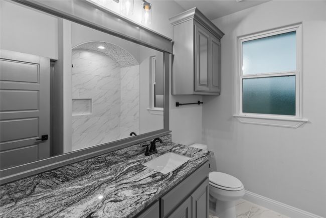 Bathroom with marble look tiles, vanity, and a tile shower | Image 24