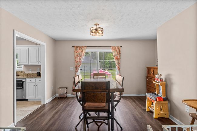Dining space featuring dark wood finished floors and a textured ceiling | Image 9