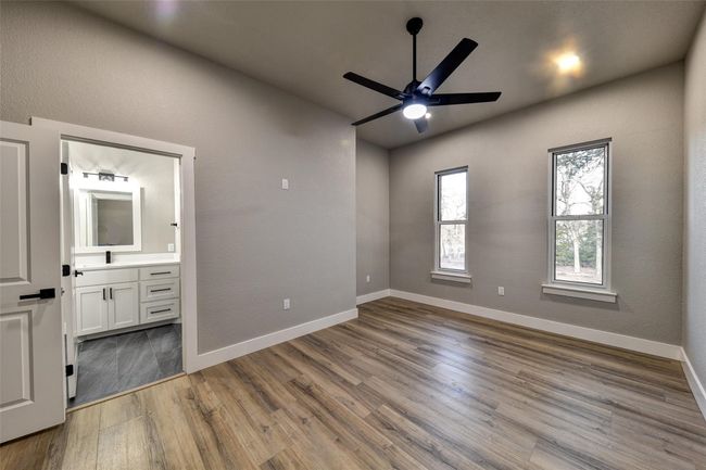 Unfurnished bedroom featuring hardwood / wood-style floors, connected bathroom, and ceiling fan | Image 28