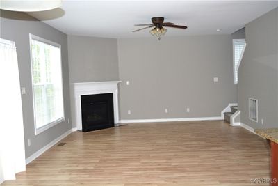 Unfurnished living room with light hardwood / wood-style flooring and ceiling fan | Image 3