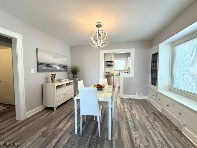 Dining space with a healthy amount of sunlight, a notable chandelier, and dark wood-style flooring | Image 5