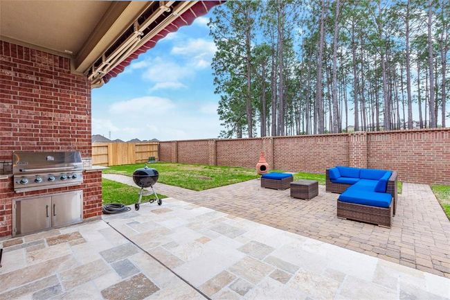 Enjoy the outdoors from the flagstone covered back patio area with outdoor gas grill, sink and storage. | Image 8