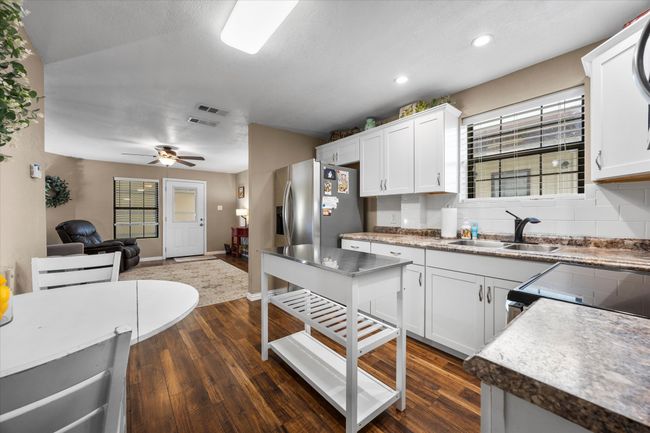 Kitchen featuring stainless steel refrigerator with ice dispenser, open floor plan, plenty of natural light, dark wood-style flooring, and recessed lighting | Image 14