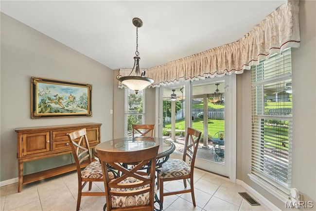 Dining area featuring light tile patterned floors, healthy amount of natural light, and vaulted ceiling | Image 7