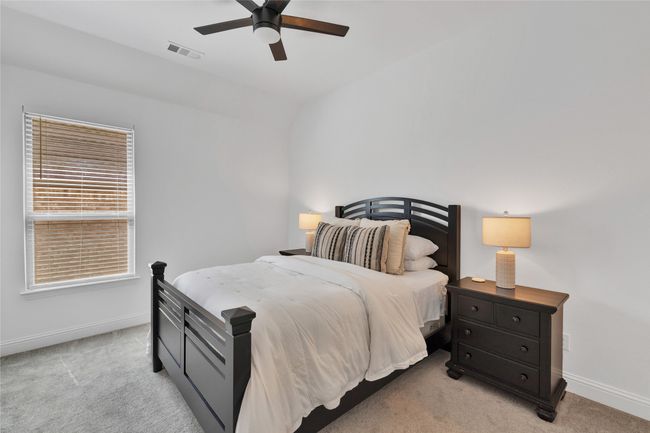 Bedroom with light carpet, baseboards, vaulted ceiling, and ceiling fan | Image 6