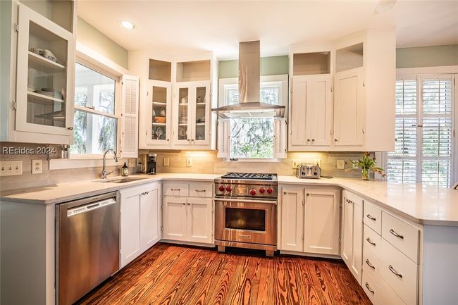 Kitchen with appliances with stainless steel finishes, wood-type flooring, exhaust hood, and plenty of natural light | Image 19
