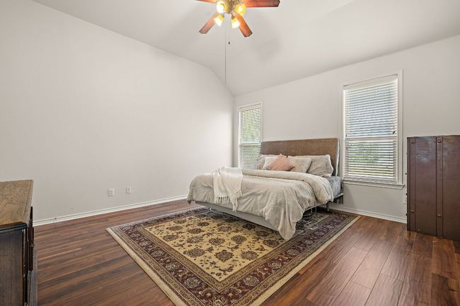 Bedroom featuring lofted ceiling, dark wood-style floors, baseboards, and a ceiling fan | Image 17