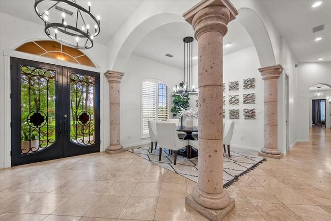 The dramatic iron double doors add a bold, custom touch to the grand entryway, setting the tone for what’s inside. | Image 6