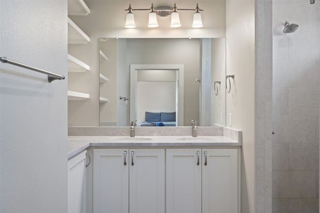 Bathroom with double vanity and a tile shower | Image 35