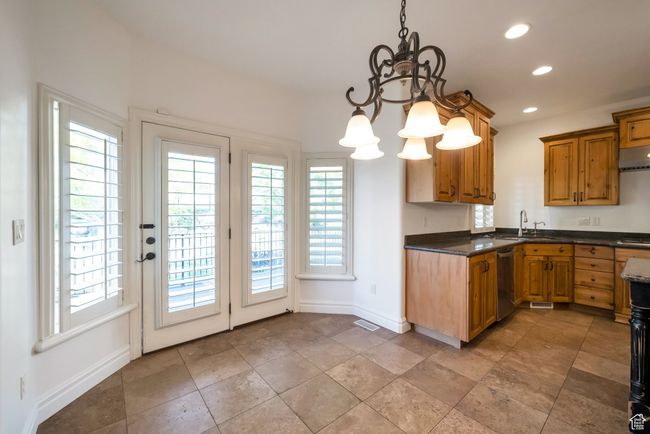 Kitchen with a sink, baseboards, dishwasher, recessed lighting, and a notable chandelier | Image 11