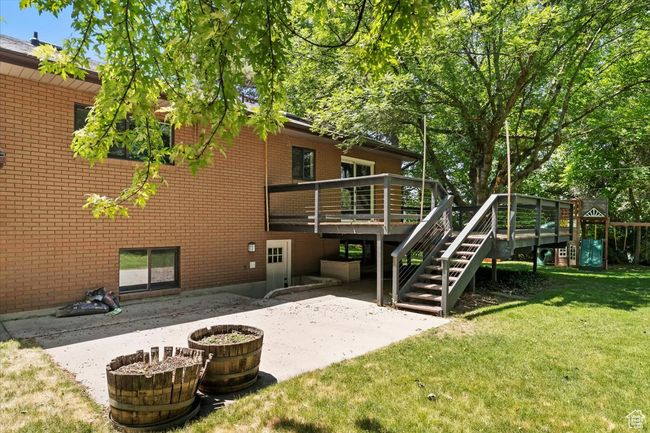 Back of house with a lawn, a patio, brick siding, a wooden deck, and stairway | Image 63