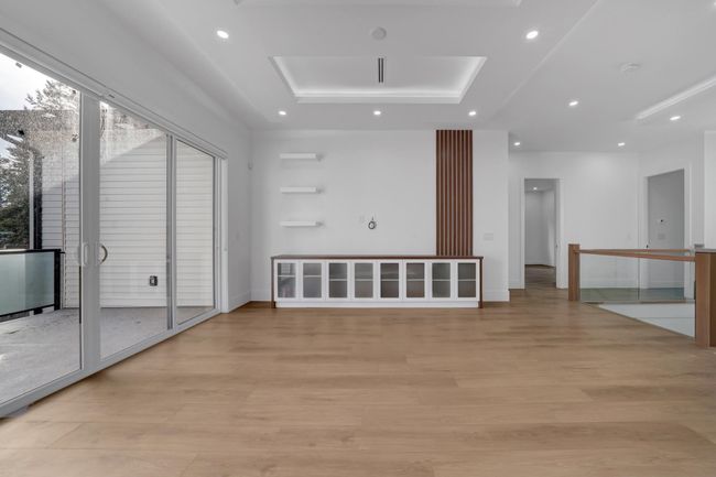 Empty room featuring a raised ceiling, light wood-style flooring, recessed lighting, and baseboards | Image 6