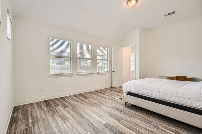 Bedroom with wood finished floors and lofted ceiling | Image 14