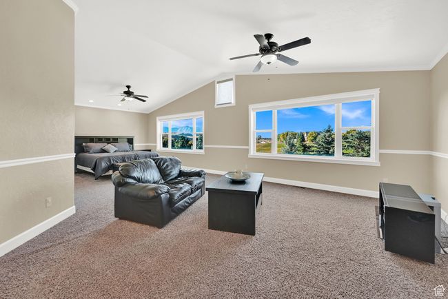 Carpeted living room with lofted ceiling, ceiling fan, and plenty of natural light | Image 47