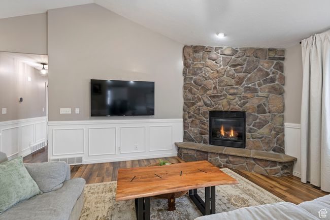 Living room with vaulted ceiling, dark hardwood / wood-style floors, and a fireplace | Image 7