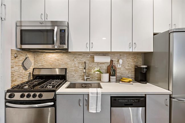 Kitchen featuring stainless steel appliances, light countertops, a sink, and backsplash | Image 4