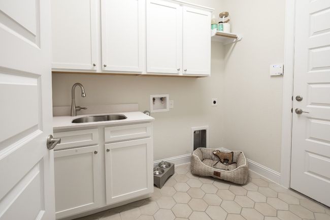 Washroom featuring cabinet space, hookup for an electric dryer, hookup for a washing machine, and baseboards | Image 9