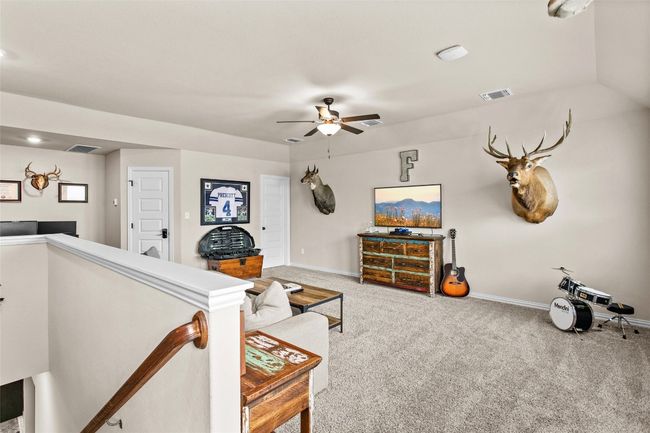 Carpeted living room featuring ceiling fan and baseboards | Image 24