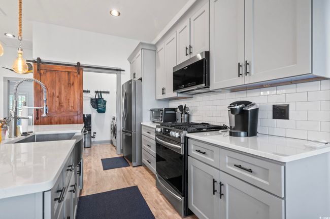 Kitchen featuring appliances with stainless steel finishes, light countertops, and light wood-style flooring | Image 6