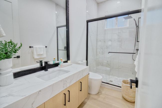 Full bathroom featuring vanity, a shower stall, and toilet | Image 11