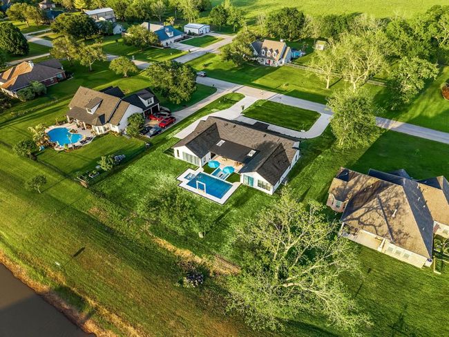 This stunning waterfront property features a spacious backyard with a sleek in-ground pool and spa, offering the perfect blend of luxury and outdoor living. Situated in a peaceful neighborhood, the home boasts a generous lot with beautifully maintained landscaping and a private setting ideal for entertaining or relaxing. | Image 45