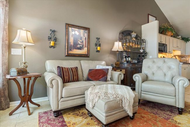 Living room featuring light tile patterned floors, baseboards, and vaulted ceiling | Image 16