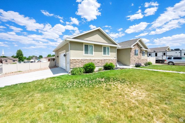 Single story home with stone siding, stucco siding, concrete driveway, and an attached garage | Image 29