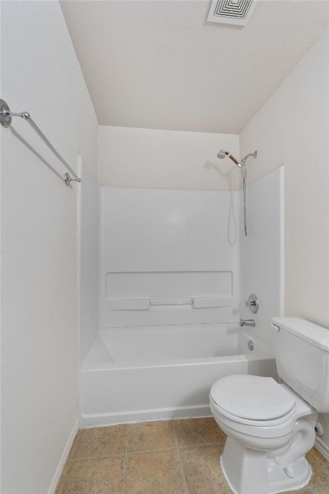 Full bathroom featuring shower / bath combination, toilet, and baseboards | Image 20