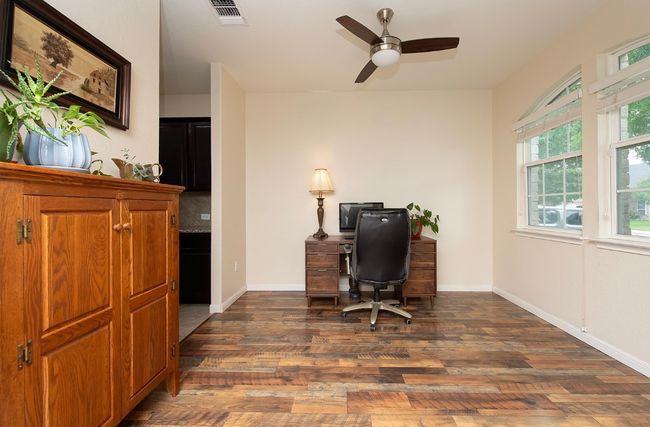 Office space featuring dark wood-style flooring, a ceiling fan, and baseboards | Image 9