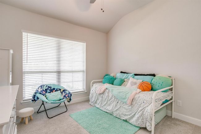 Carpeted bedroom featuring lofted ceiling, multiple windows, baseboards, and ceiling fan | Image 32