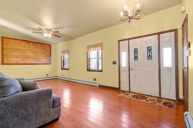 Foyer entrance with a baseboard heating unit, hardwood / wood-style flooring, ceiling fan | Image 4