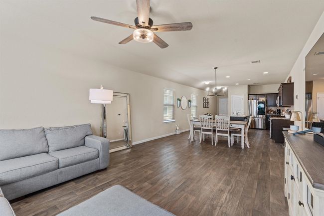 Living room with dark wood finished floors, ceiling fan, a chandelier, and recessed lighting | Image 13