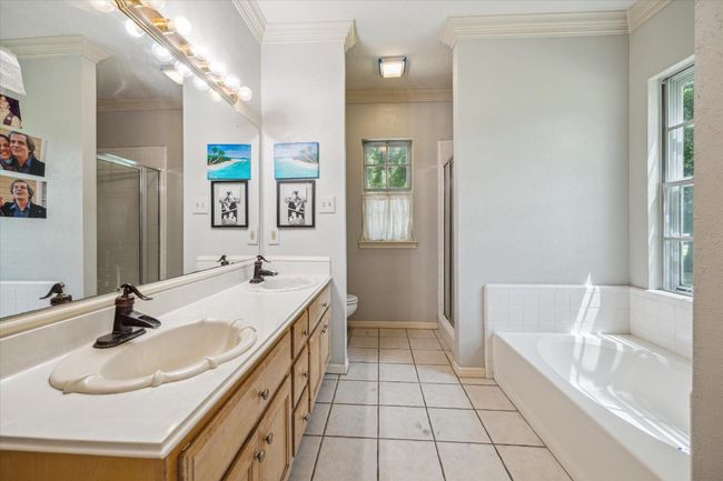 Charming two-story home with a welcoming front porch, nestled among mature trees. Features dormer windows, a classic gable roof, and a spacious yard, perfect for enjoying nature and outdoor activities. | Image 12