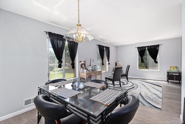 Dining area featuring a chandelier, wood finished floors, and healthy amount of natural light | Image 7
