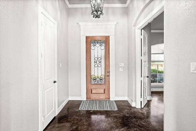 Foyer entrance featuring finished concrete floors, baseboards, and ornamental molding | Image 6