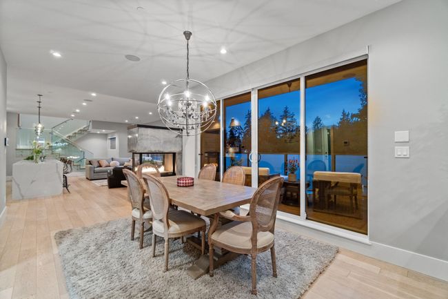 Dining area featuring wood finished floors, a chandelier, recessed lighting, and stairs | Image 10