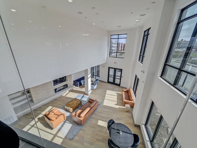 Living area featuring a fireplace, light wood-type flooring, a towering ceiling, and recessed lighting | Image 21