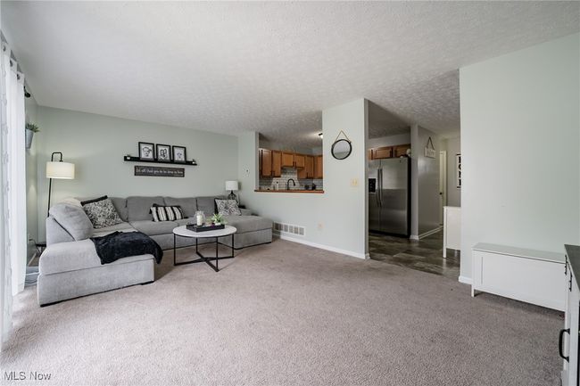 Carpeted living room featuring a textured ceiling | Image 9
