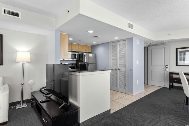 Kitchen featuring a peninsula, visible vents, a textured ceiling, and appliances with stainless steel finishes | Image 12