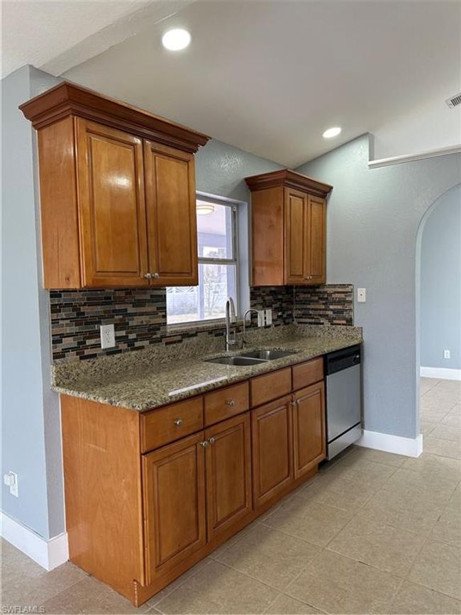 Kitchen with dishwasher, brown cabinetry, arched walkways, and recessed lighting | Image 11